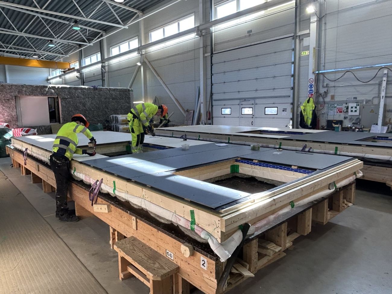 Équipe Puzzle assemblant un panneau de plancher en usine